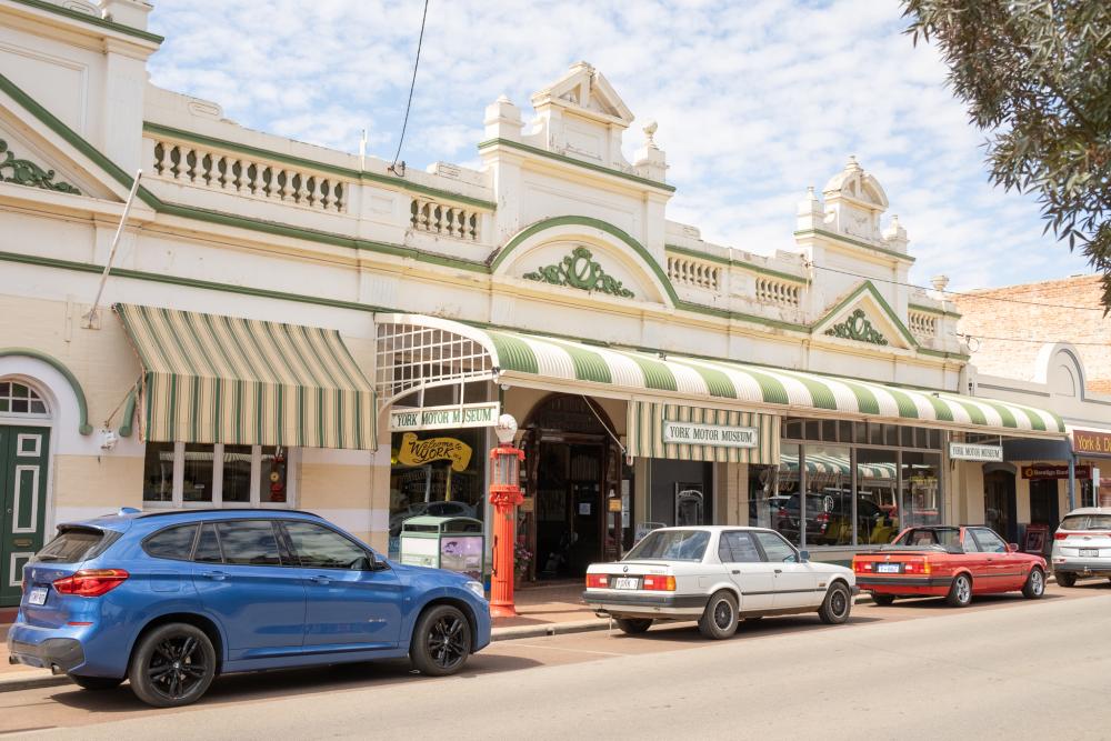 Exterior of an old building with cars parked out the front