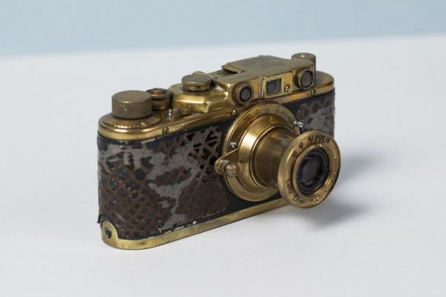 A gold plated camera with crocodile skin