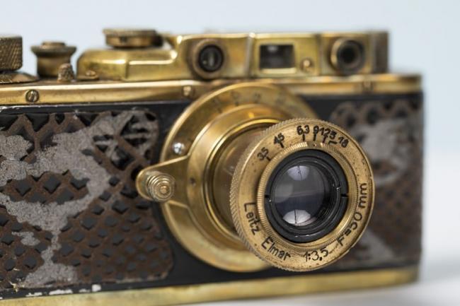 A gold plated camera with crocodile skin