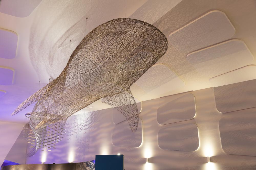 Giant whale shark wire artwork hanging from a ceiling.