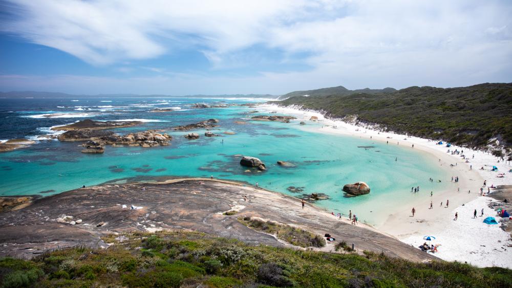 A beach with blue water and rocks