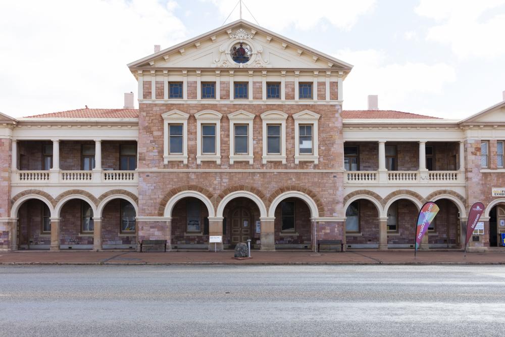 Large two story bulding with decorate arches along the ground floor facade