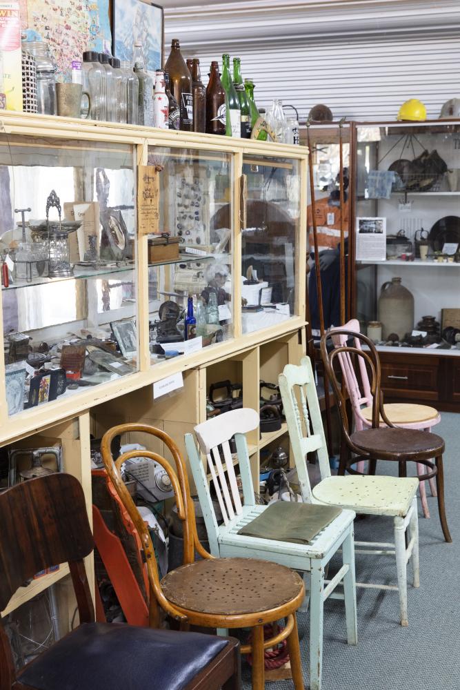 A room with many chairs and a glass cabinet