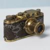 A gold plated camera with crocodile skin