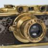 A gold plated camera with crocodile skin